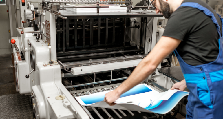 Artcal - Man Grabbing Printed Graphic From Print Machine - Professional Print Shop Blog