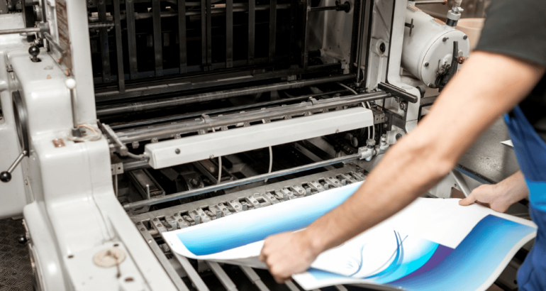 Artcal - Professional Paper Printer Being Loaded With Large Paper With Blue Graphics - Professional Paper Printing Services Blog