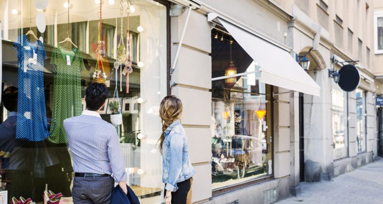 Couple looking at clothes displayed on store window